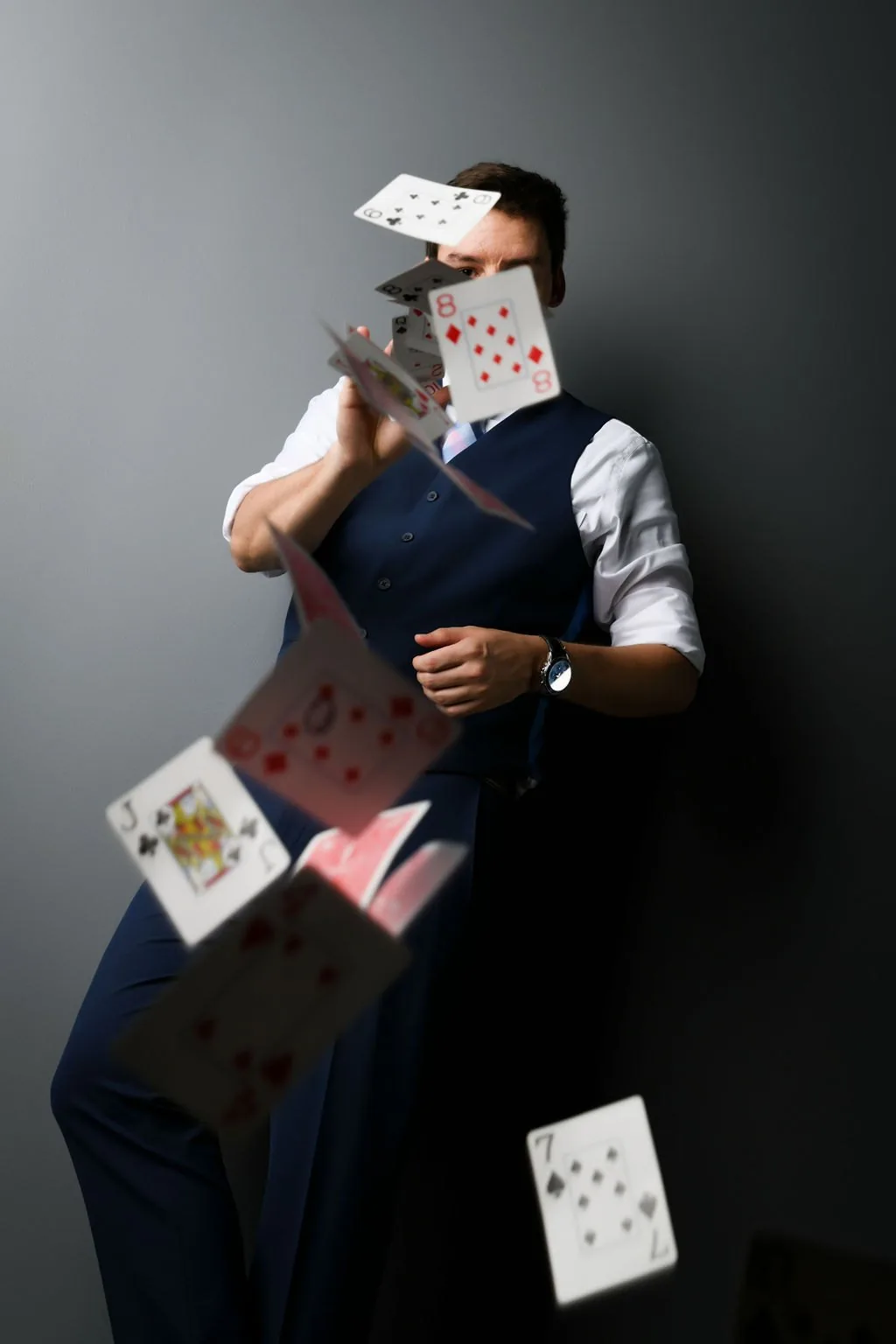 Michael Bloemeke throwing playing cards toward the camera in a studio portrait