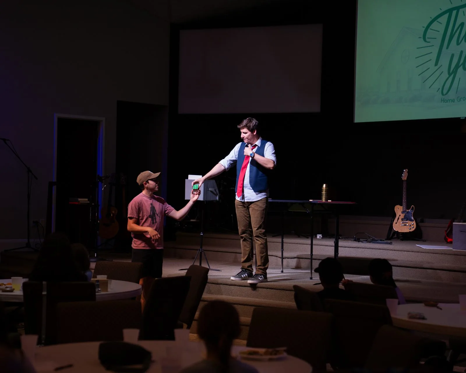 Michael Bloemeke performing on stage with an audience volunteer at a community event