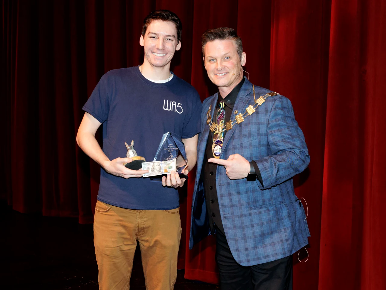 Michael Bloemeke holding his first-place Winter Carnival of Magic award.